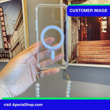 Load image into Gallery viewer, Image of customer holding Aporia MagSafe Clear Case - Pearl Wristlet Strap for iPhone 15/14/13/12 while at the art museum featuring stunning Art Paintings
