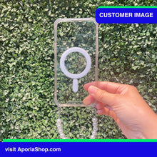 Load image into Gallery viewer, Image of customer holding Aporia MagSafe Clear Case - Pearl Wristlet Strap for iPhone 15/14/13/12
